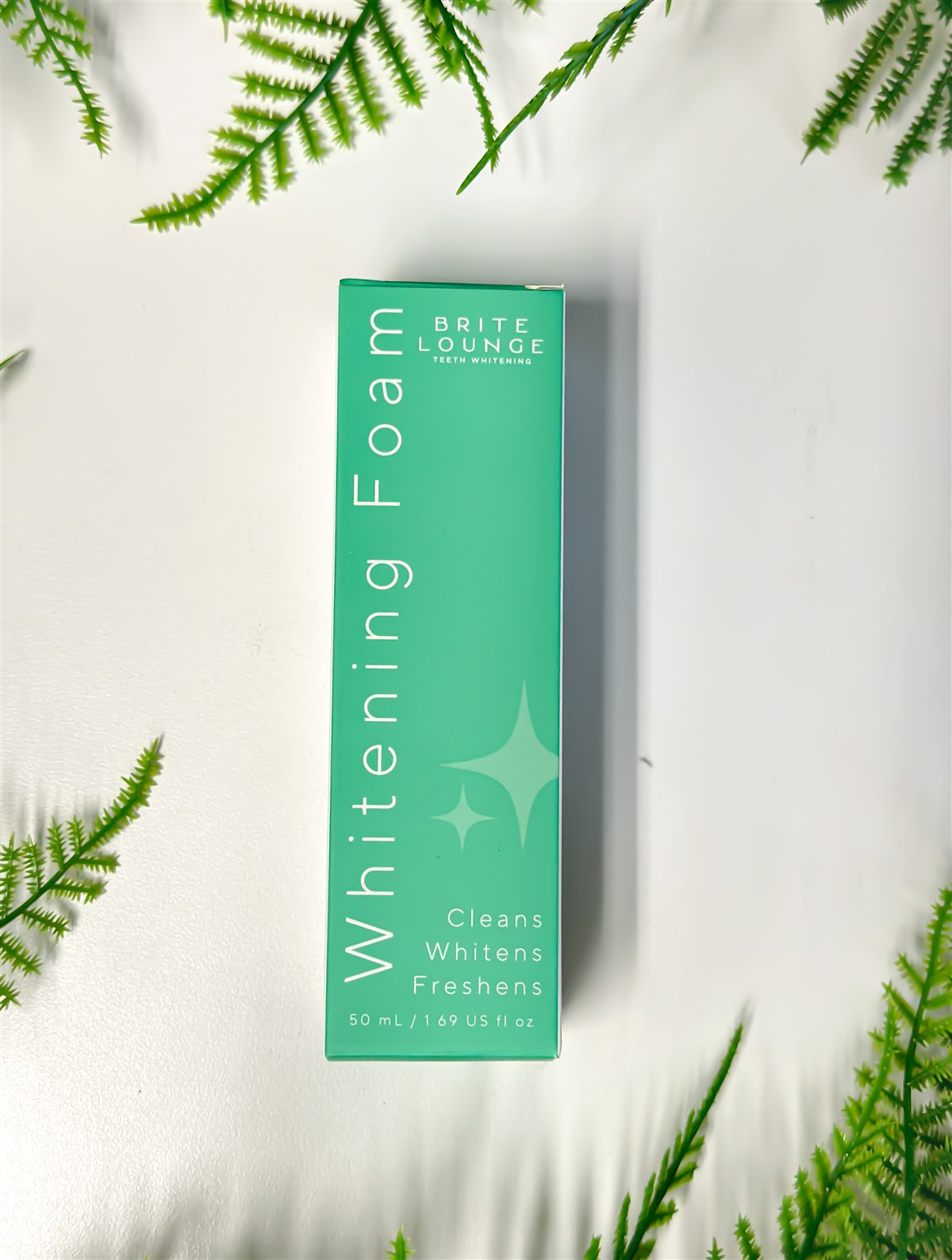 The Brite Lounge Whitening Foam box, photographed with greenery